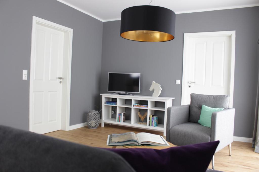 a living room with a chair and a tv at Heideträume Appartements in Undeloh