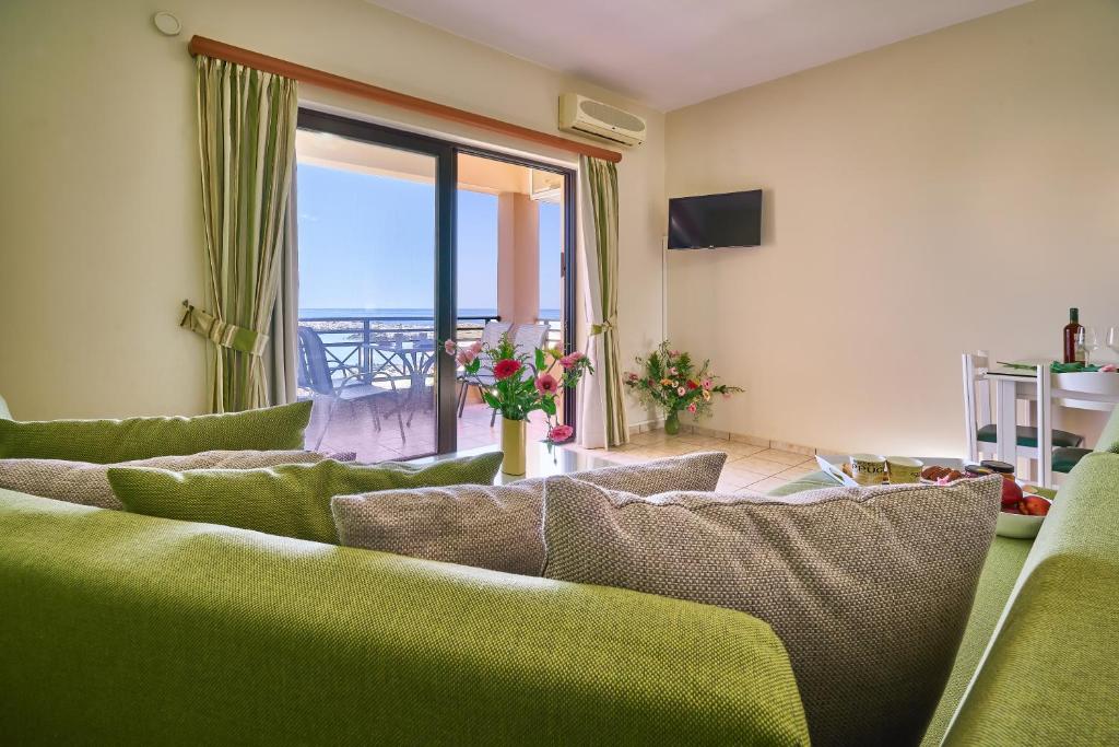 a living room with a couch and a view of the ocean at Nanakis Beach Apartments in Stavros