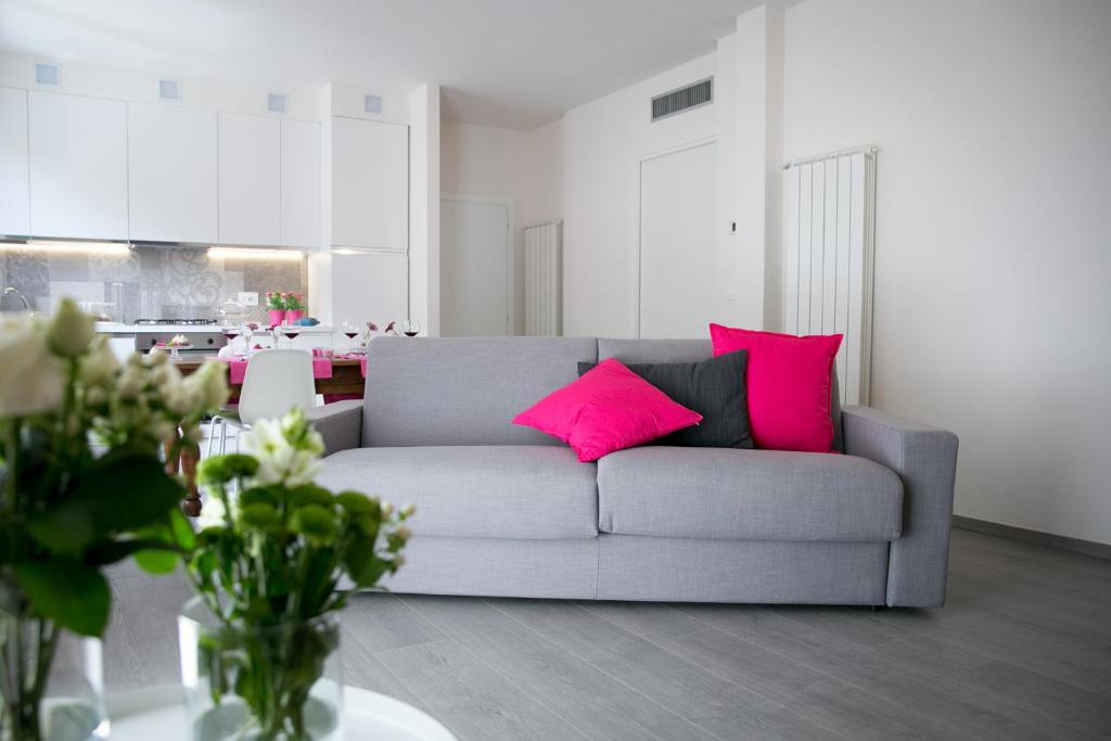 sala de estar con sofá gris y almohadas rosas en ML House, en Costa Volpino