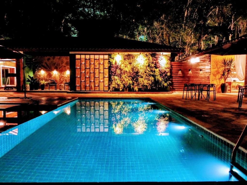 a swimming pool in front of a house at night at Pousada Santa Thereza in Serra Negra