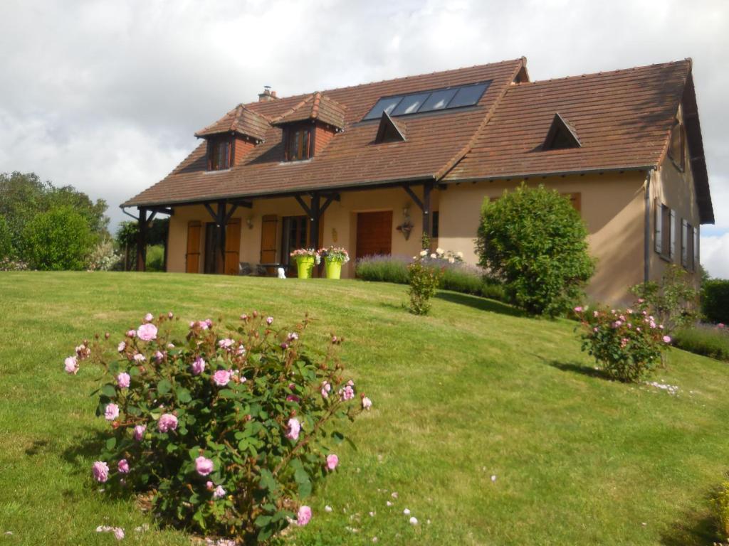 a house with pink roses in the yard at Maison Maton in La Roche-lʼAbeille