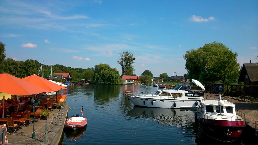 two boats are docked at a dock on a river at Neukalener Stadthaus Zum Alten Schmied in Neukalen