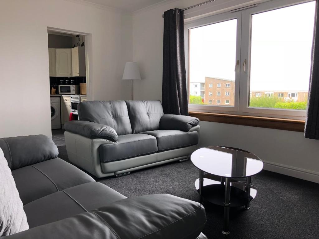 uma sala de estar com um sofá e uma mesa em Dysart Sea View Apartment em Dysart