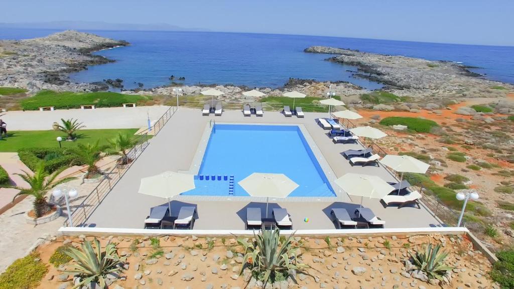 an aerial view of a resort with a swimming pool and the ocean at Nanakis Beach Luxury Apartments in Stavros