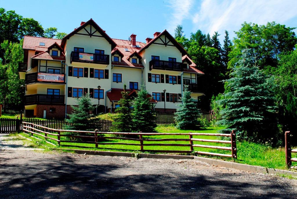 um grande edifício com uma cerca em frente em Apartamenty Sun Seasons 24 - Rezydencja Parkowa em Szklarska Poręba