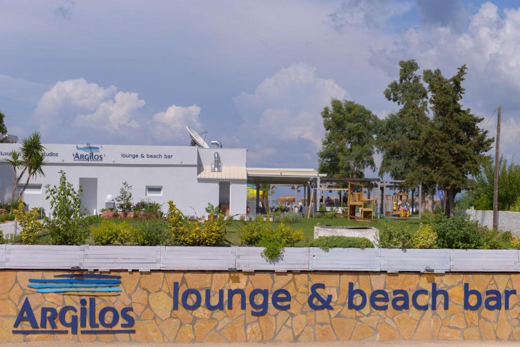 a sign on a wall in front of a playground at Argilos in Sidari