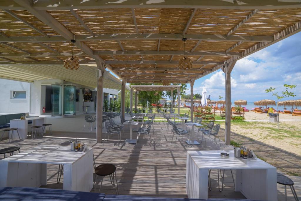 a patio with tables and chairs on the beach at Argilos in Sidari