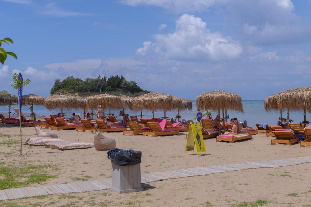 a beach with many chairs and straw umbrellas at Argilos in Sidari