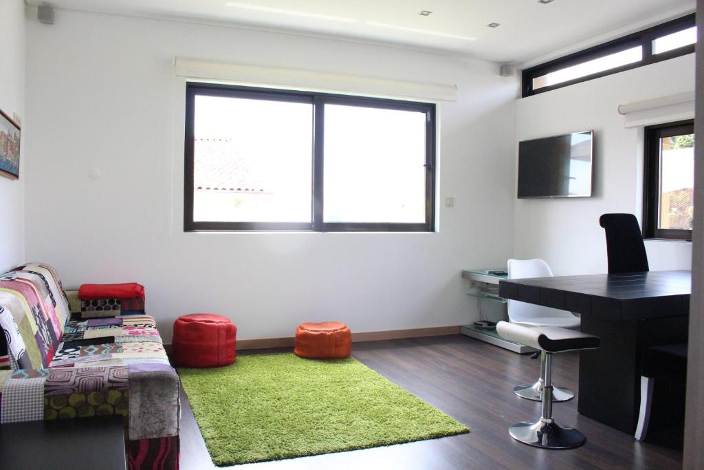 a room with a desk and a table with a green rug at Casa Viriato in Santa Maria Da Feira