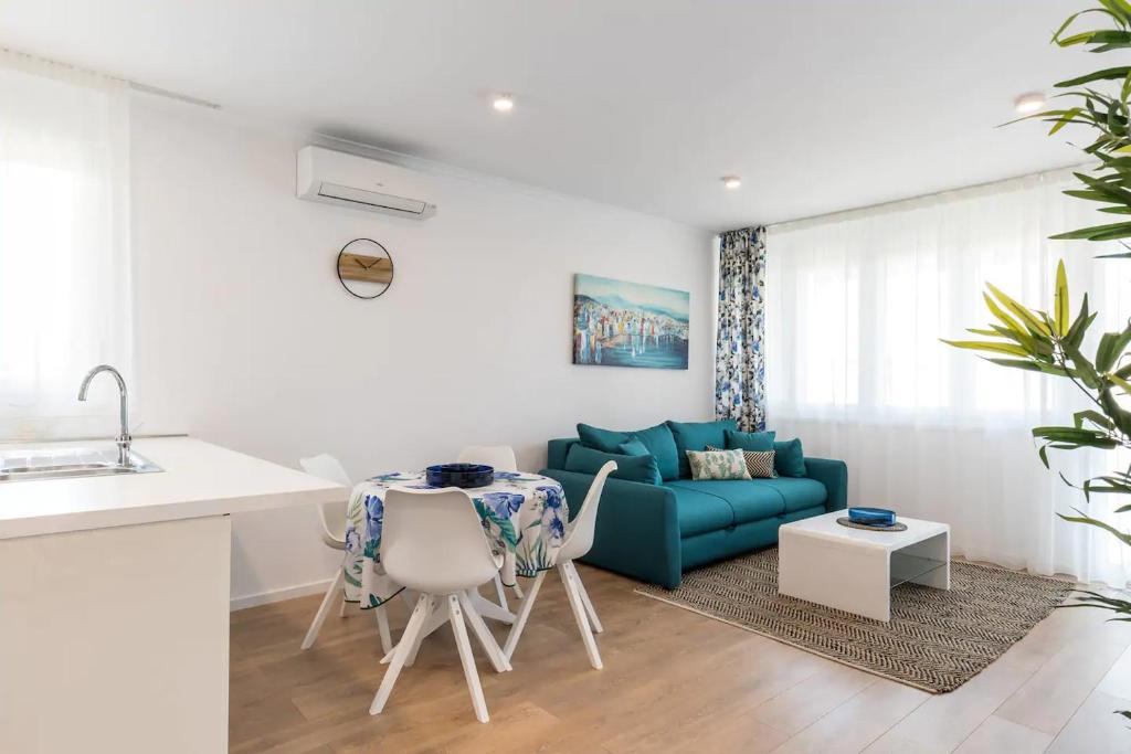 a kitchen and a living room with a blue couch at Relax & Recharge SEA VIEW Apartment in Split