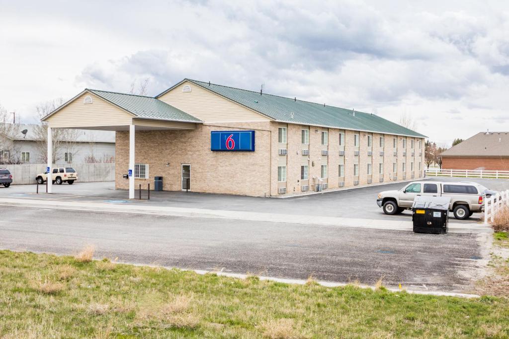 a large building with a parking lot in front of it at Motel 6-Rigby, ID in Lorenzo