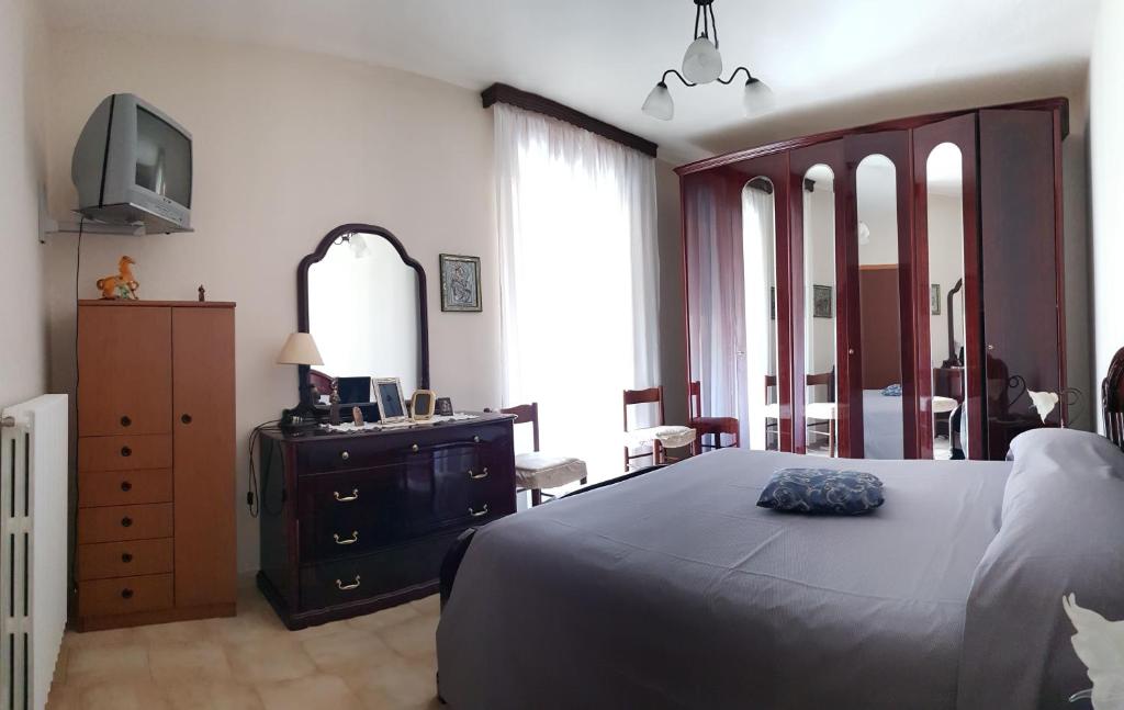 a bedroom with a bed and a dresser and a television at B&B Via Roma in Viggianello
