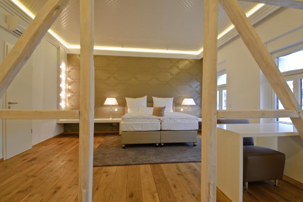 Dormitorio tipo loft con 2 camas y escritorio en Helvetia Suites, en Düsseldorf