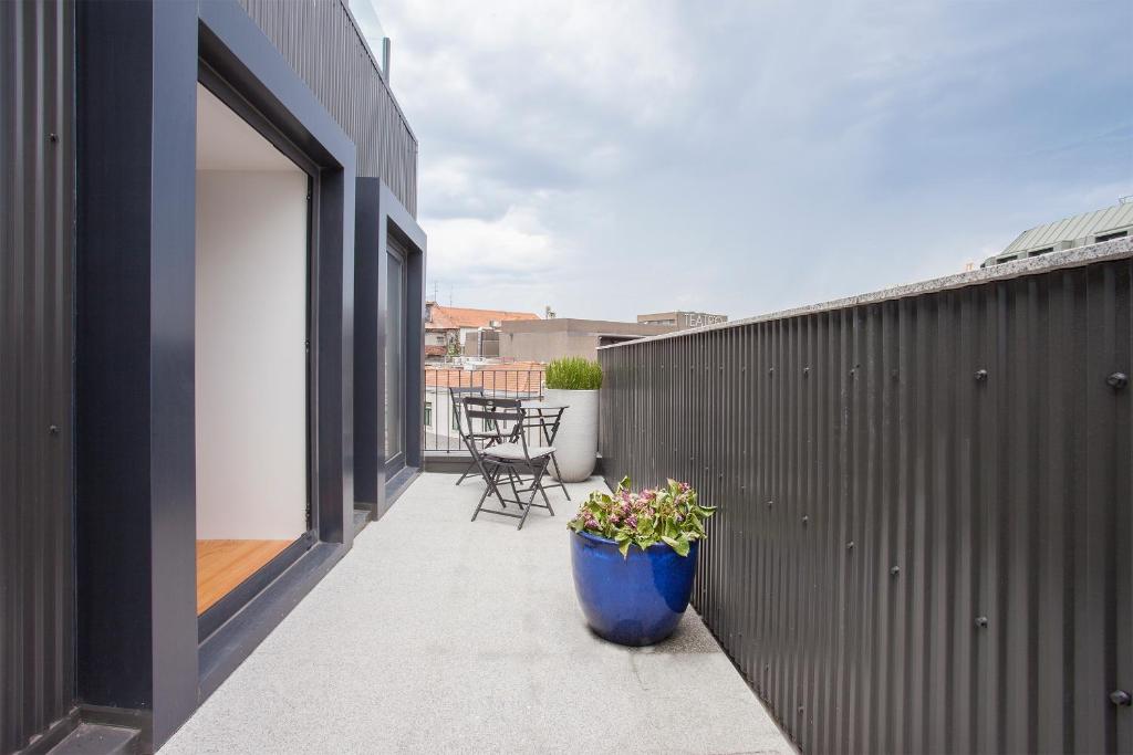 a balcony with a blue flower pot on a building at Liiiving in Porto | Downtown Luxury Studio in Porto