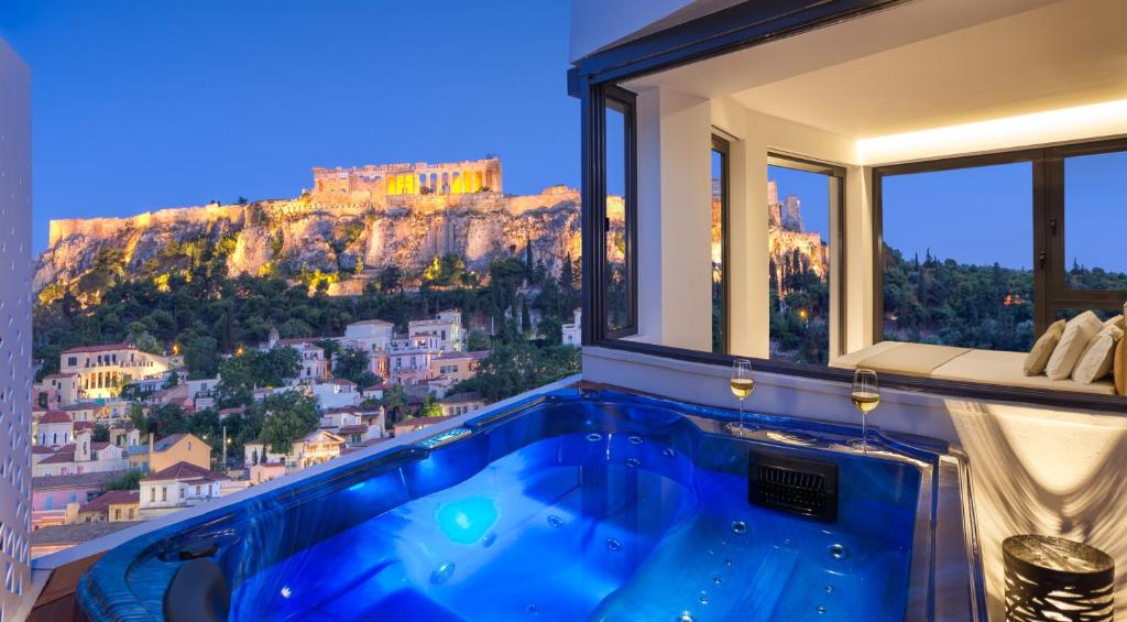 a hot tub in a room with a mountain view at Athens Avaton Suites in Athens