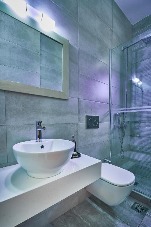 a bathroom with a sink and a glass shower at Nanakis Beach Apartments in Stavros