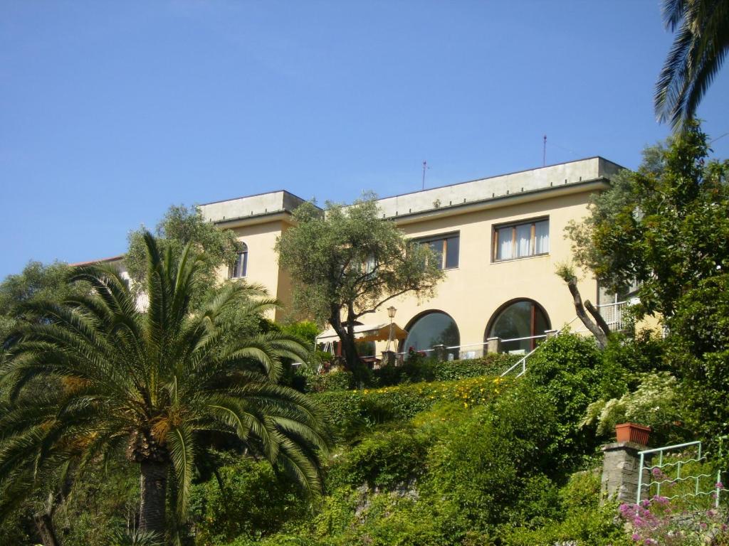 a building with a palm tree in front of it at Villa Il Respiro in Zoagli