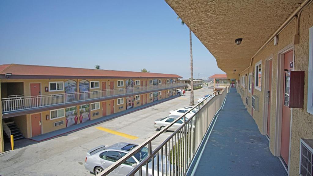 a row of buildings with cars parked in a parking lot at Los Angeles Inn & Suites - LAX in Los Angeles