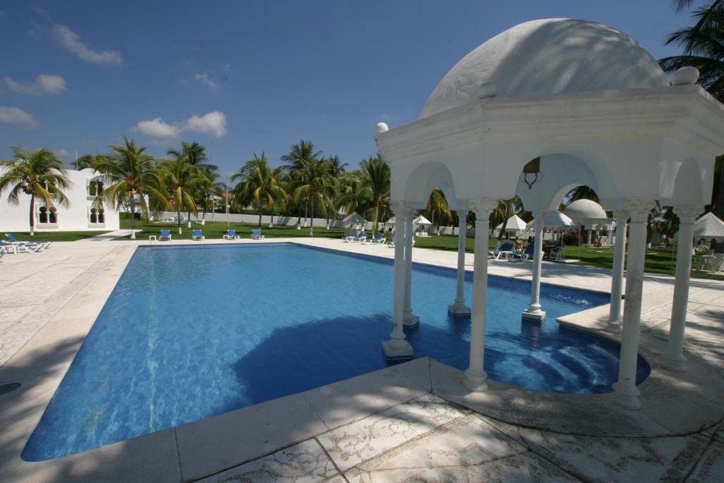 a swimming pool with a blue umbrella on top of it at Hotel Aldea del Bazar & Spa in Puerto Escondido