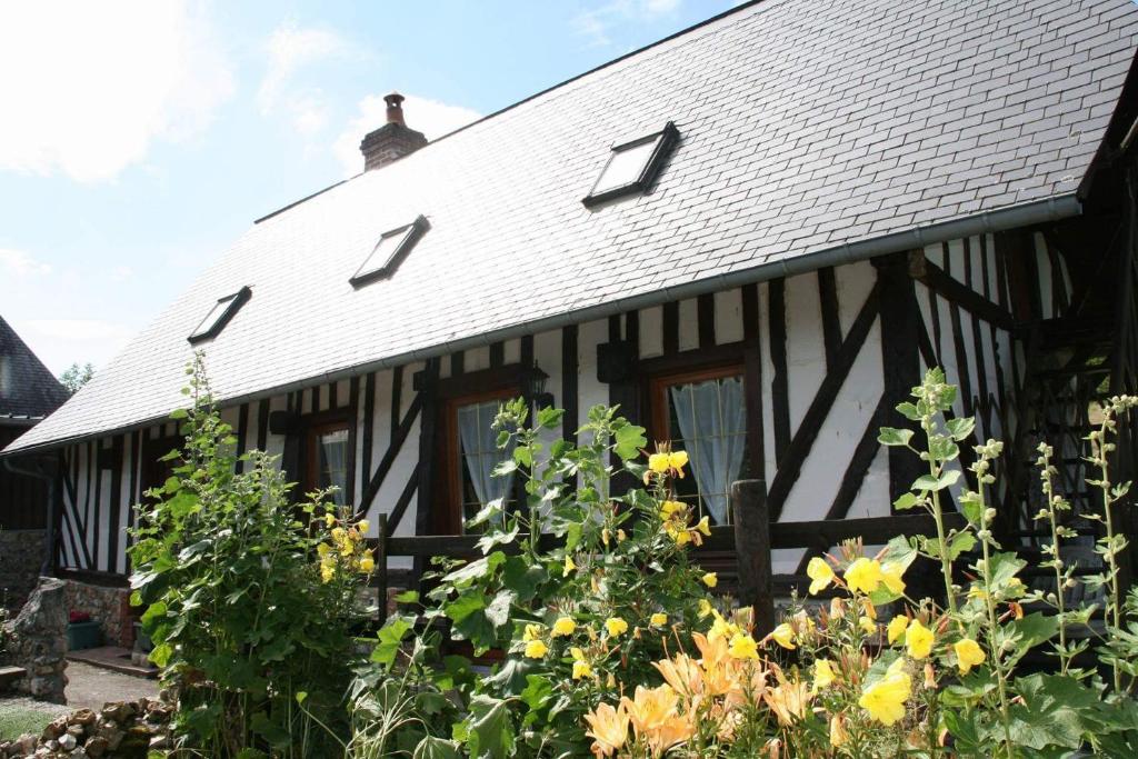 ein schwarzes und weißes Haus mit Blumen davor in der Unterkunft Le Clos des Hortensias in Toutainville