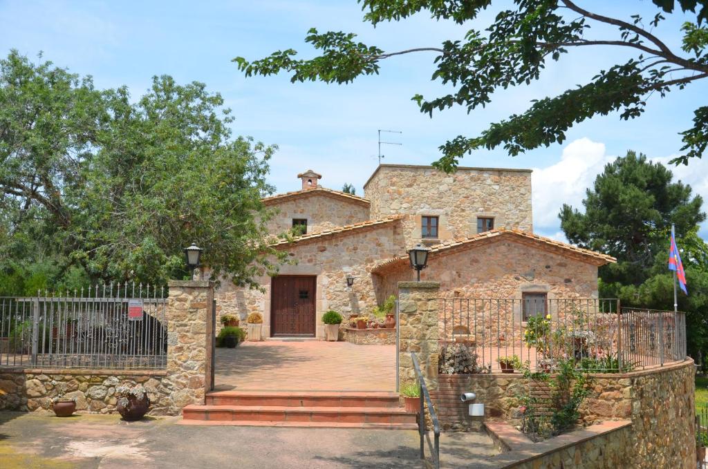 a stone house with a gate in front of it at VILLAS COSETTE Molí d'en Tarrés in Santa Cristina d'Aro