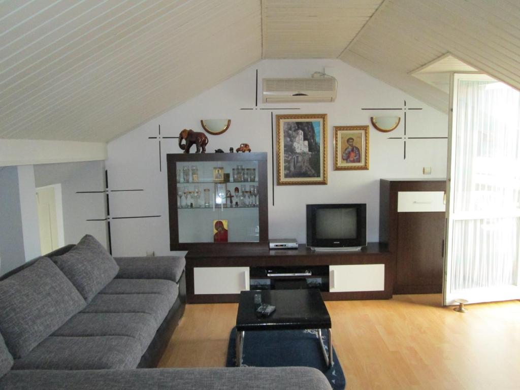 a living room with a couch and a tv at Smjestaj „Cubrilo" in Herceg-Novi
