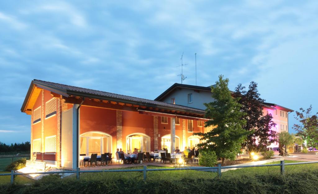 un edificio con mesas y sillas al aire libre por la noche en Agriturismo Podere Dell'Angelo en Pasiano di Pordenone