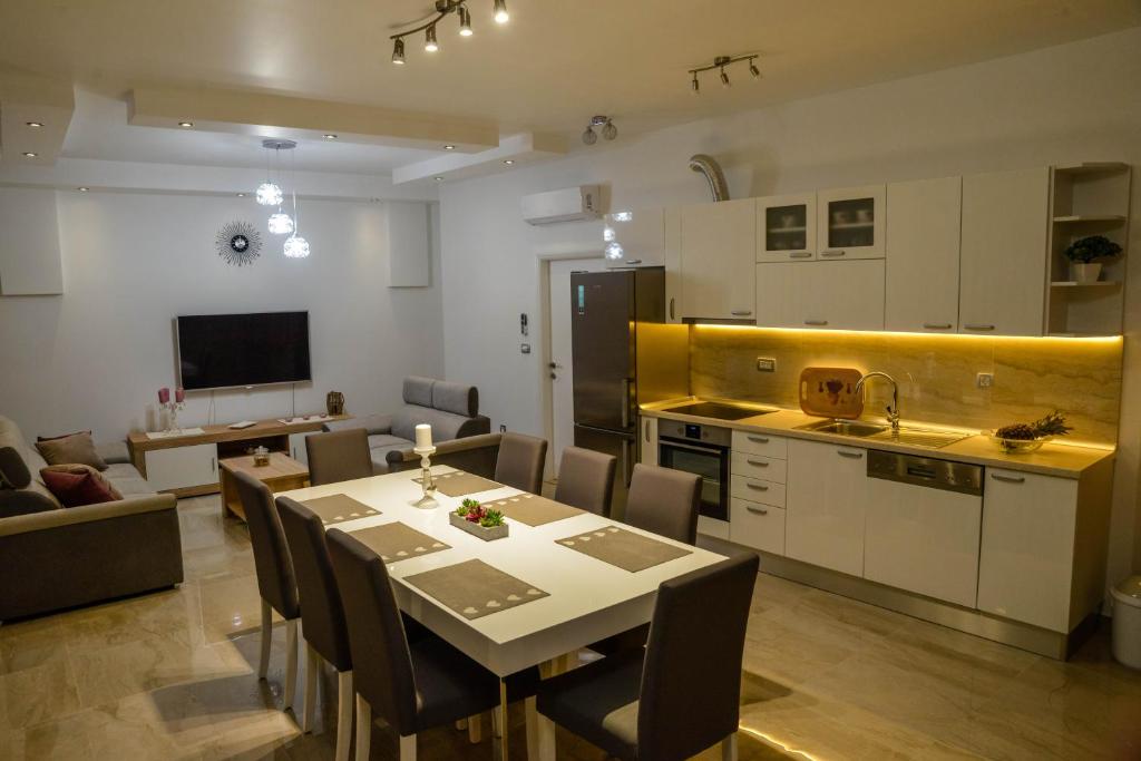 uma cozinha e sala de estar com mesa e cadeiras em Apartmani Olujic Imotski em Imotski