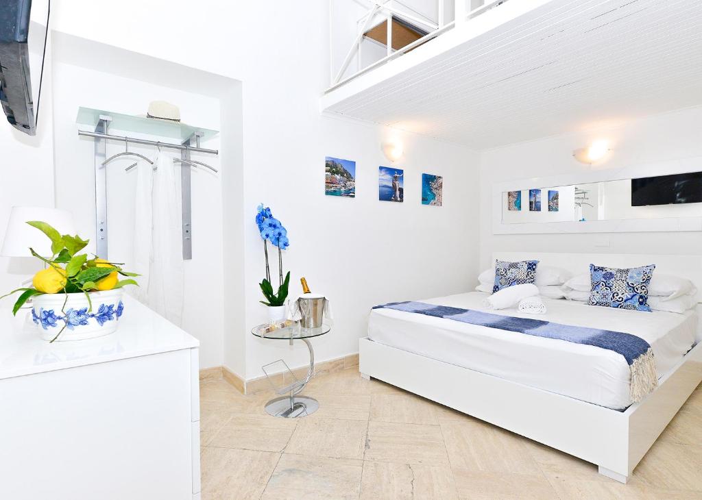 a white bedroom with a bed in a room at La Perla Blu in Capri