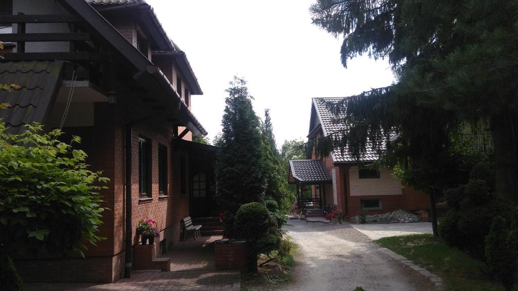 an alley between two buildings with trees and a house at Pokoje Gościnne Na Górach in Kazimierz Dolny