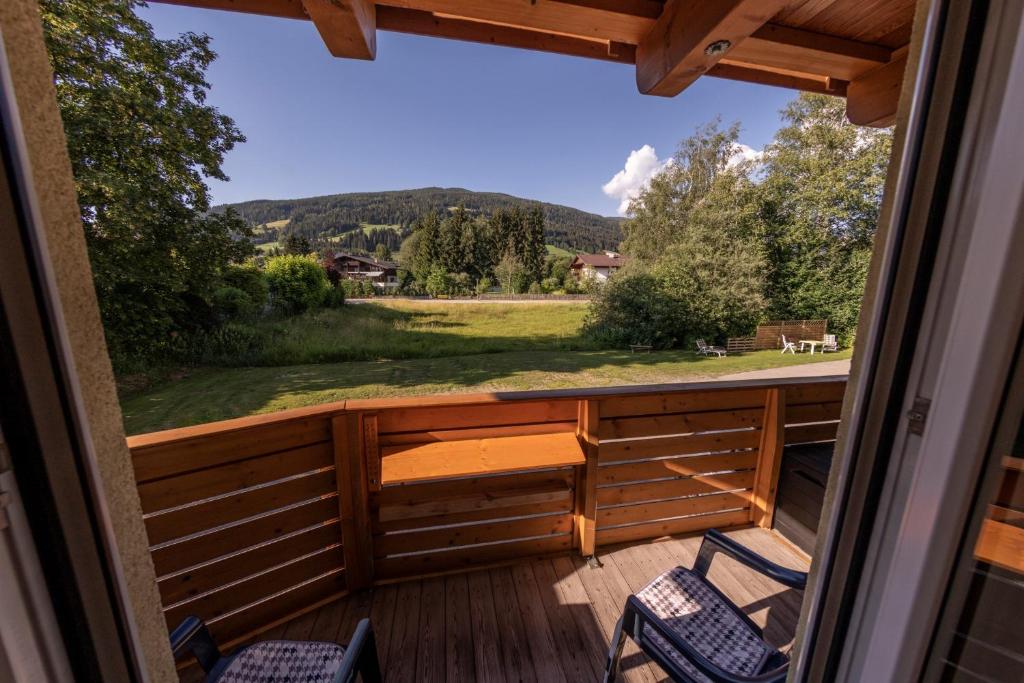 porche con sillas y vistas al campo en Powderia Family & Freelance Apartment in the center of Ski Amadé, en Altenmarkt im Pongau