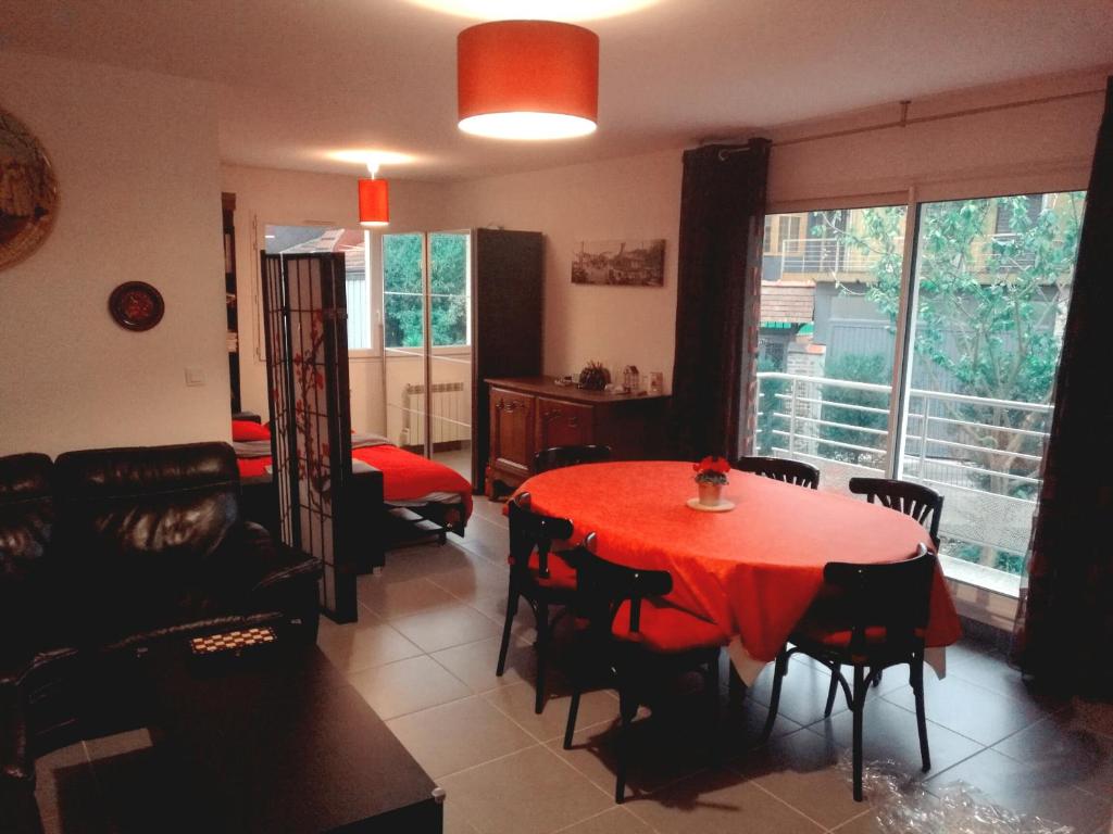 a living room with a red table and chairs at Grand appartement proche CHU in Rouen