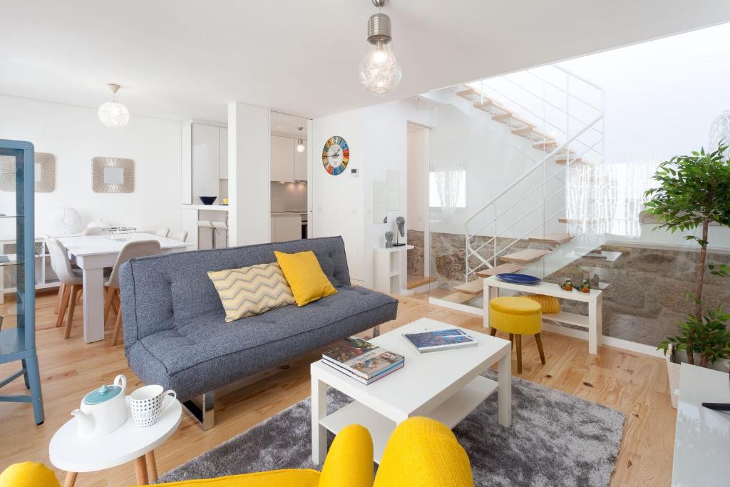 uma sala de estar com um sofá e uma mesa em Urban Views Townhouse Arrábida no Porto