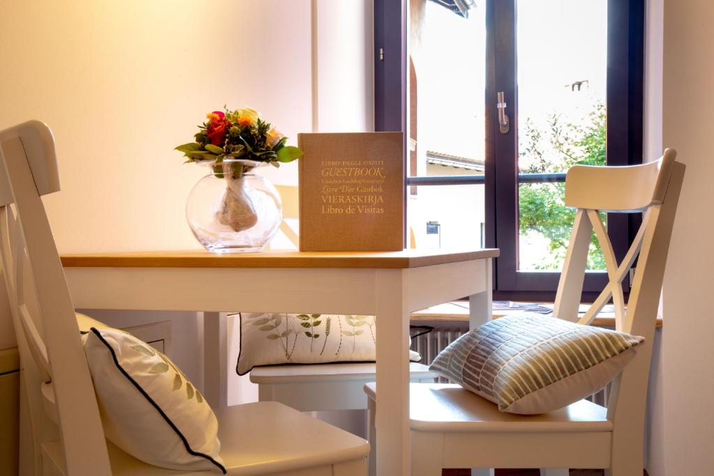 a table and chairs with a vase of flowers on it at Borghese Apartment in Locarno