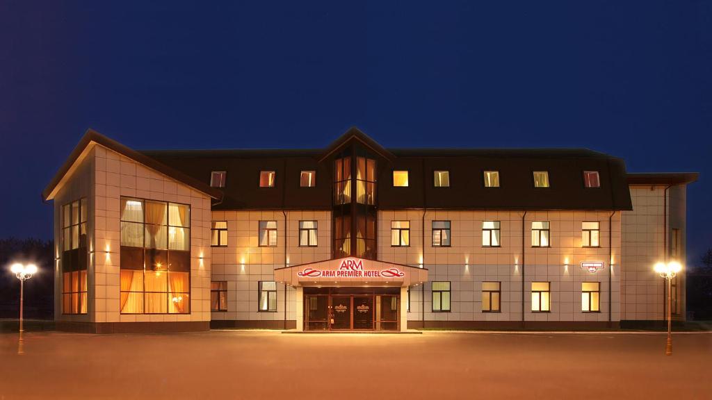 a large building with a sign on it at night at Arm Premier Hotel in Cherepovets