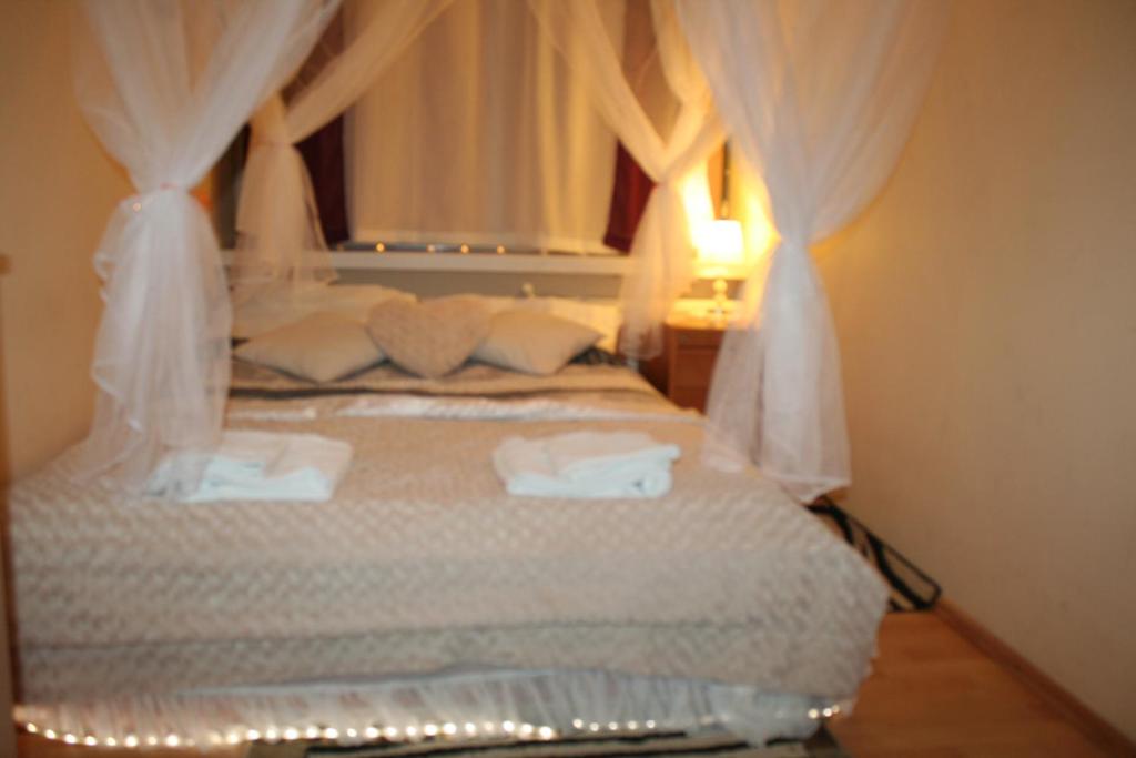 a bedroom with a bed with white sheets and pillows at Apartament Królewski 3 pokojowy Centrum in Olsztyn