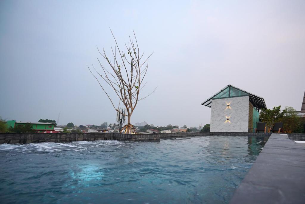 A rooftop pool overlooking low-rise buildings and a hazy urban landscape.