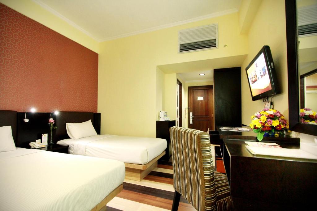 Postel nebo postele na pokoji v ubytování Pandanaran Hotel