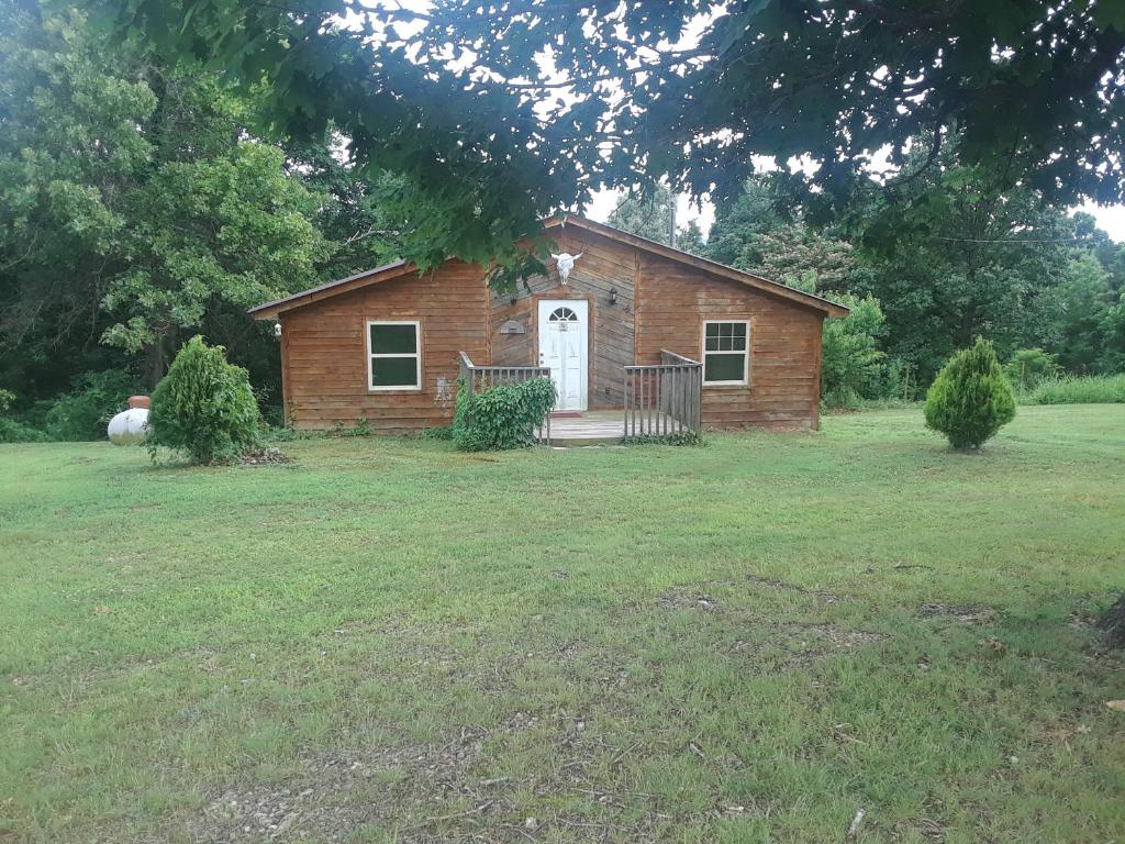 a small brick house with a white door at Cedar cabin located on a buffalo farm in Marshall
