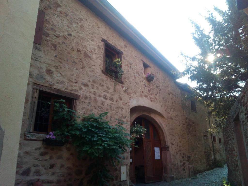 - un vieux bâtiment en pierre avec une porte et une fenêtre dans l'établissement Le gite de Coco, à Riquewihr