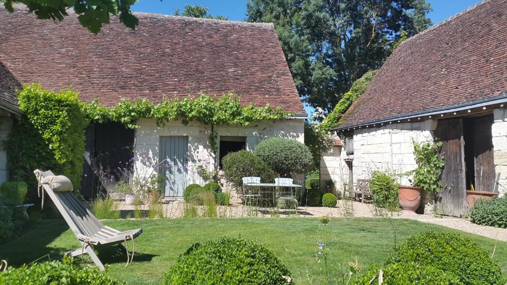 un patio con un banco frente a una casa en Le Clos Falaw, en Azay-sur-Cher