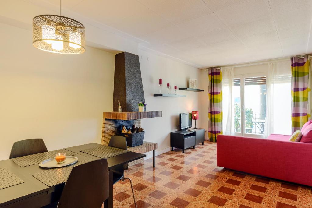 トッサ・デ・マールにあるNS Apartamentsのリビングルーム(赤いソファ、暖炉付)