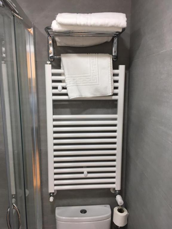 a bathroom with a shower and a toilet and towels at Rincón de Gran Vía in Madrid