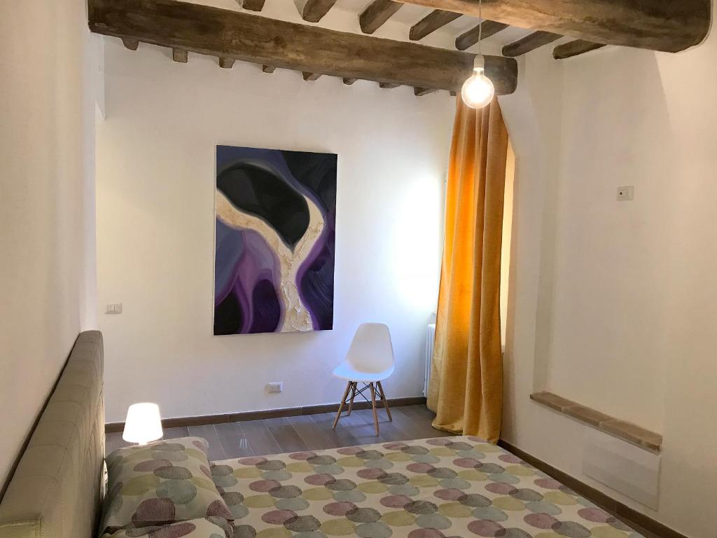 a bedroom with a bed and a painting on the wall at Appartamenti San Pietro in Perugia