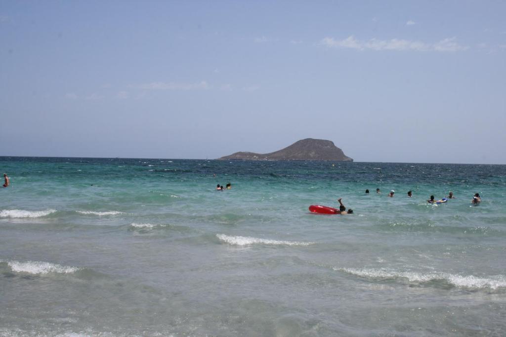 Un groupe de gens nageant dans l'océan dans l'établissement Residencial Isla Grosa, à La Manga del Mar Meno