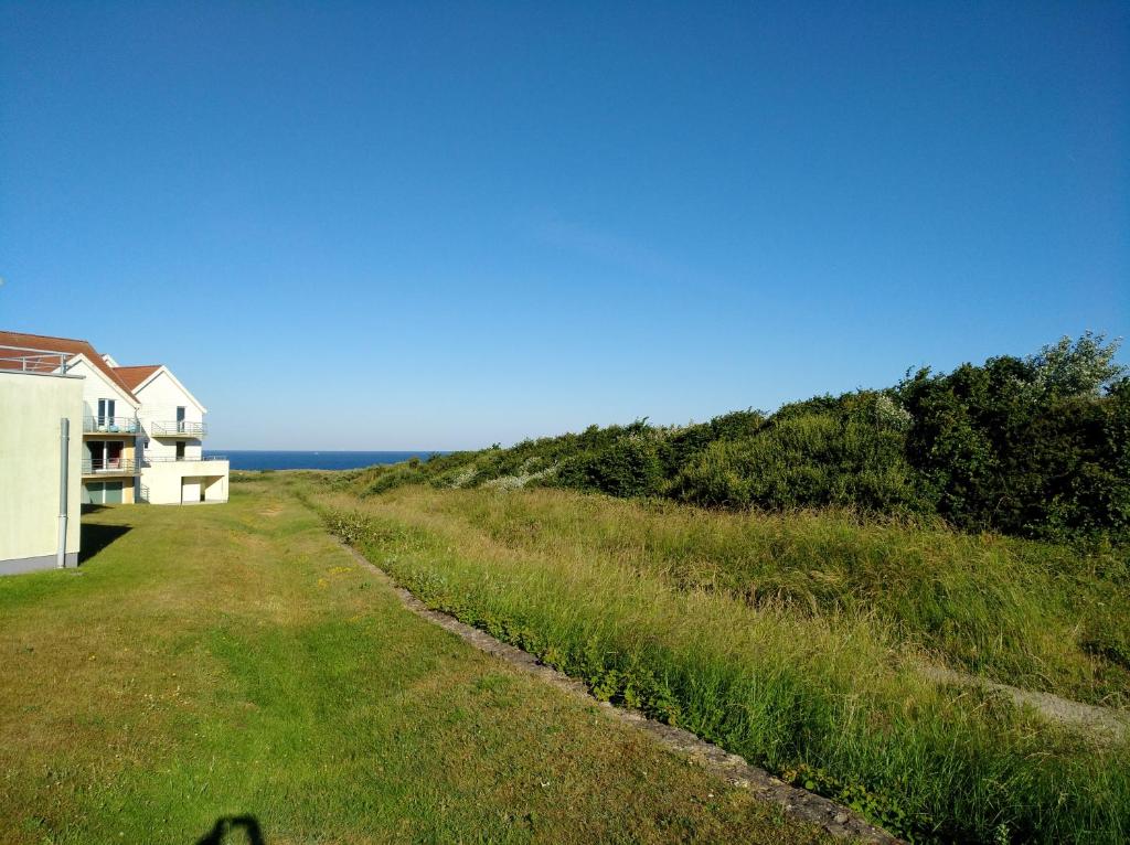 un camino de tierra que conduce a una casa y al océano en Location vue mer WIFI, en Wimereux