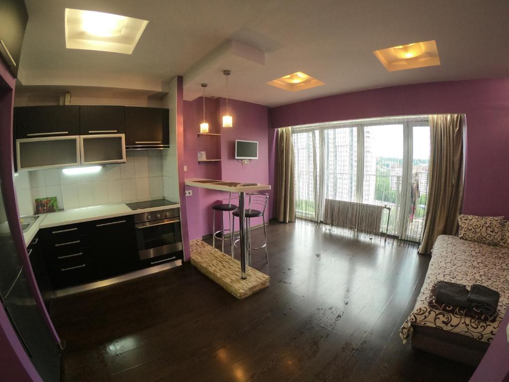 ドニプロにあるLUX apartment on Kirova 27d view 15 floorの紫の壁のキッチン、テーブルが備わります。