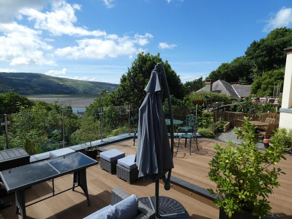 an umbrella sitting on top of a wooden deck at Bryn Melyn Apartments in Barmouth
