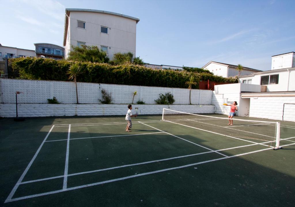 two children playing tennis on a tennis court at Esplanade Hotel in Newquay