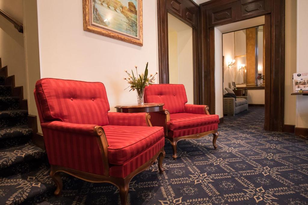 two red chairs and a table in a room at Hotel Villa Delle Rose in Rome